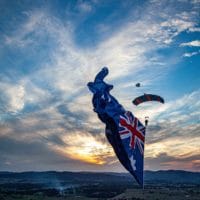 Skydiver under canopy with a flying flag