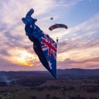 Skydiver under canopy with a flying flag