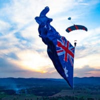 Skydiver under canopy with a flying flag