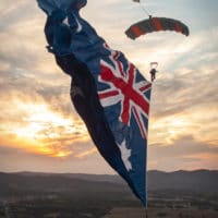 Skydiver under canopy with a flying flag