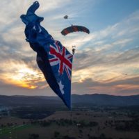 Skydiver under canopy with a flying flag