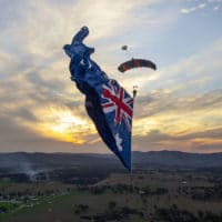Skydiver under canopy with a flying flag