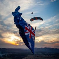 Skydiver under canopy with a flying flag