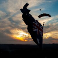 Skydiver under canopy with a flying flag