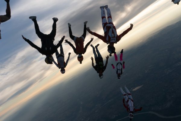 skydivers flying a tight formation during a steep angle jump