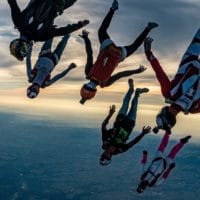 skydivers flying a tight formation during a steep angle jump