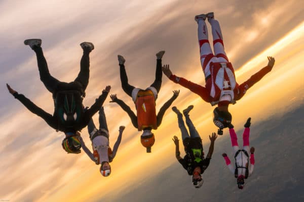 skydivers flying a tight formation during a steep angle jump