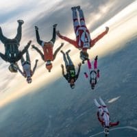 skydivers flying a tight formation during a steep angle jump
