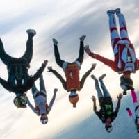 skydivers flying a tight formation during a steep angle jump