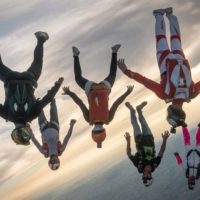 skydivers flying a tight formation during a steep angle jump