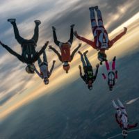 skydivers flying a tight formation during a steep angle jump