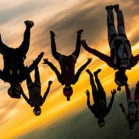 skydivers flying a tight formation during a steep angle jump