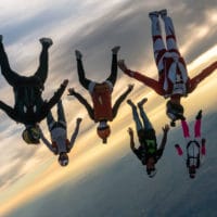 skydivers flying a tight formation during a steep angle jump