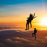 skydivers flying head up in the sunset