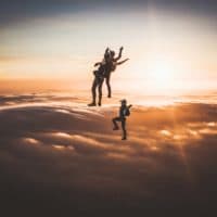 skydivers flying head up in the sunset