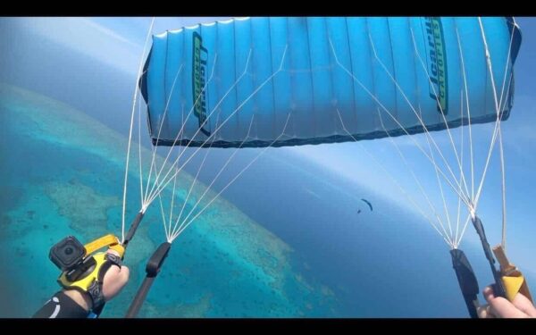 Light blue NZ Aerosports Crossfire 3 flying over the ocean while piloted by Shane Turner