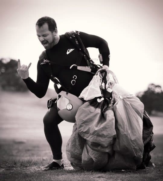 Shane Turner posing on the landing area after a good skydive with his canopy