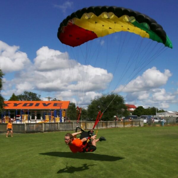 skydiver swooping Leia close to ground fully extended out of harness