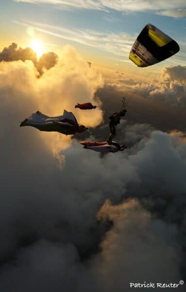 icaurs petra robin harris flying with 3 wingsuits over clouds at sunset photo credit partick reuter