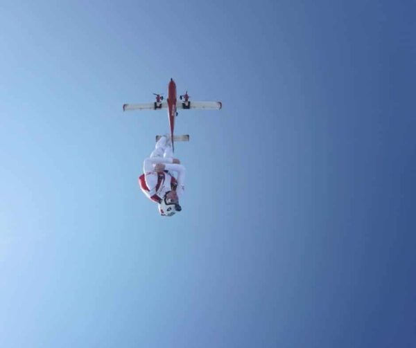 josiah rich head down freefall exit with plane behind him and blue sky