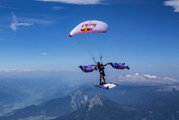 red bull skydive team xrw 3 wingsuiters docked with max manow flying icarus petra with mountains in background photo credit chris stewart