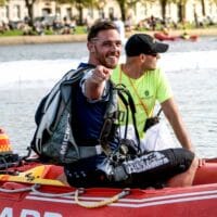 nza testie chris stewy smiling and pointing at camera sitting in life boat wearing upt container photo credit juan mayer