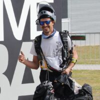 bruno geada walking back from landing area holding canopy smiling and giving a hand shaka
