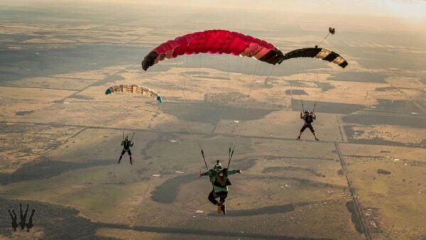 simon colmer flying icarus leia behind two canopies over barren landscape photo credit kian bullock