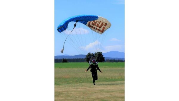 liz peace landing jvx on grass with mountains in the background photo credit carlos munoz