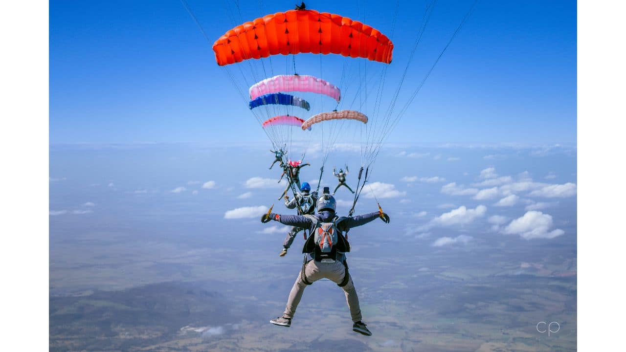 canopies flying in a line behind each other towards blue sky photo credit cameron puttee