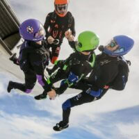 omni99 holding hands exiting plane in head down position