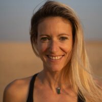 2023 karine joly smiling at camera with hair pushed to one side photo credit ewan cowie photography