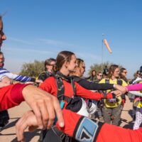women world record project 19 skydivers holding arms in formation on ground