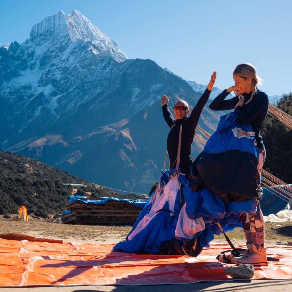 greg and karine packing their parachutes in front of everest